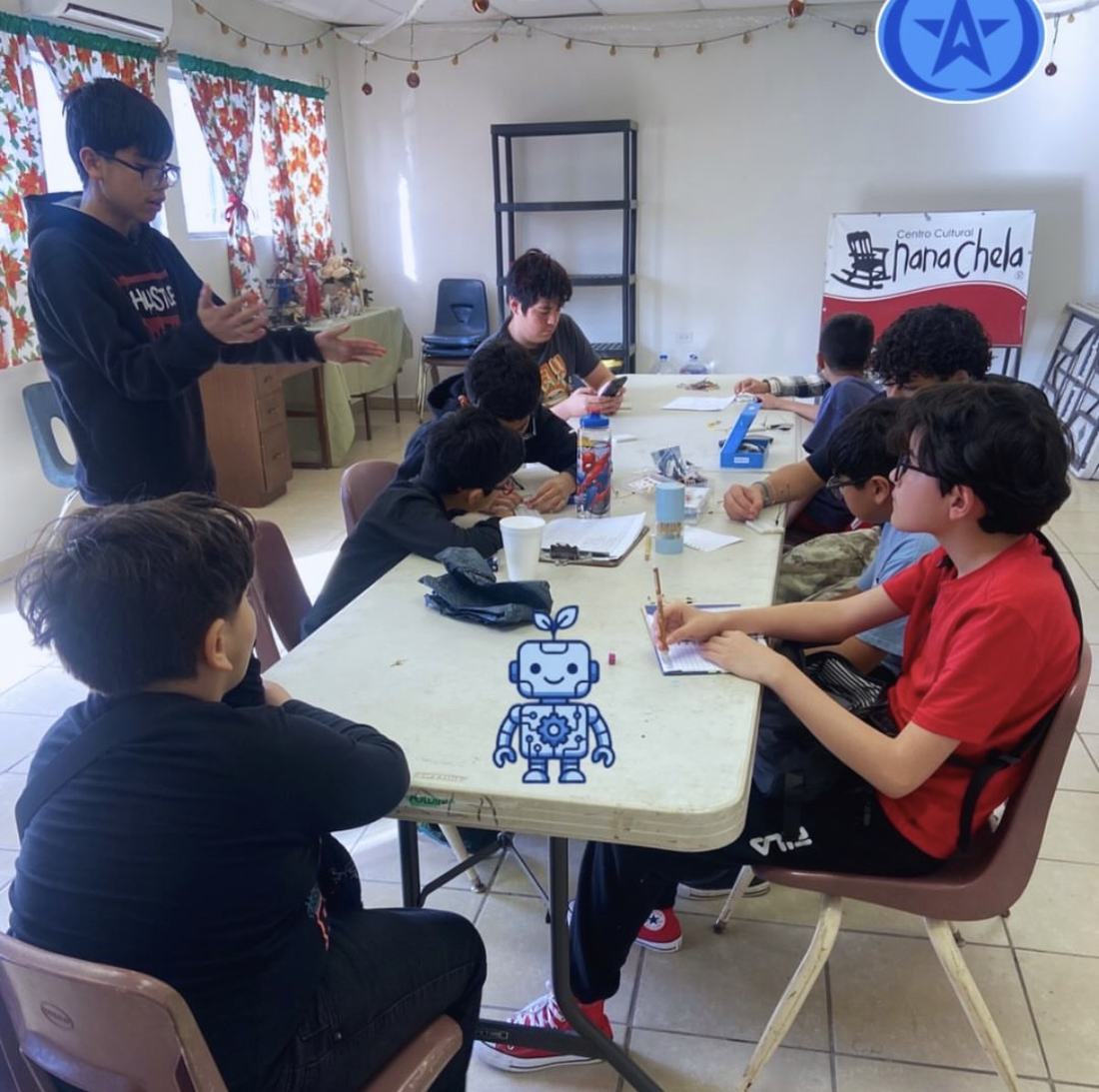 Clase gratuita de robótica de Qubiko en un salón comunitario, con mesas prestadas y material propio