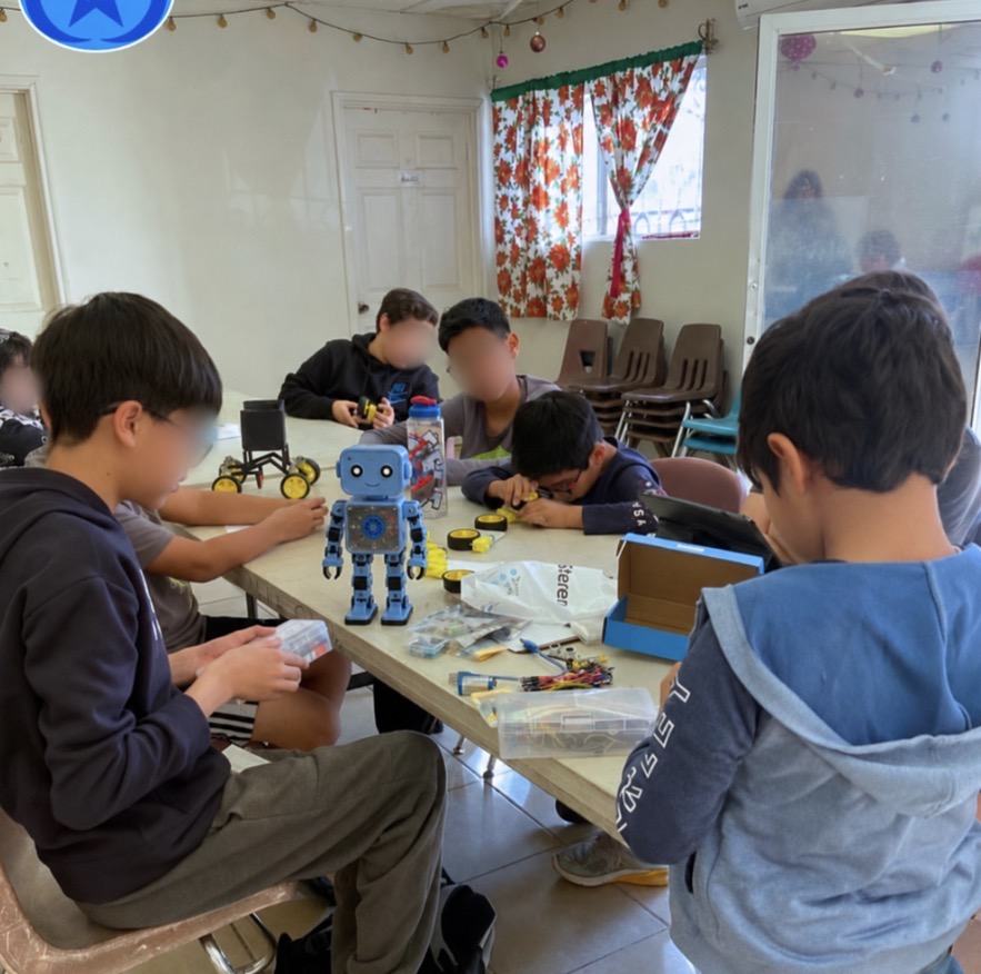 Sesión del club de robótica de Qubiko en un salón prestado, con un robot armado sobre la mesa