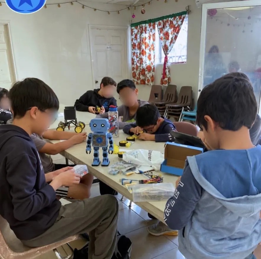 Sesión del club de robótica de Qubiko en un salón prestado, con un robot armado sobre la mesa