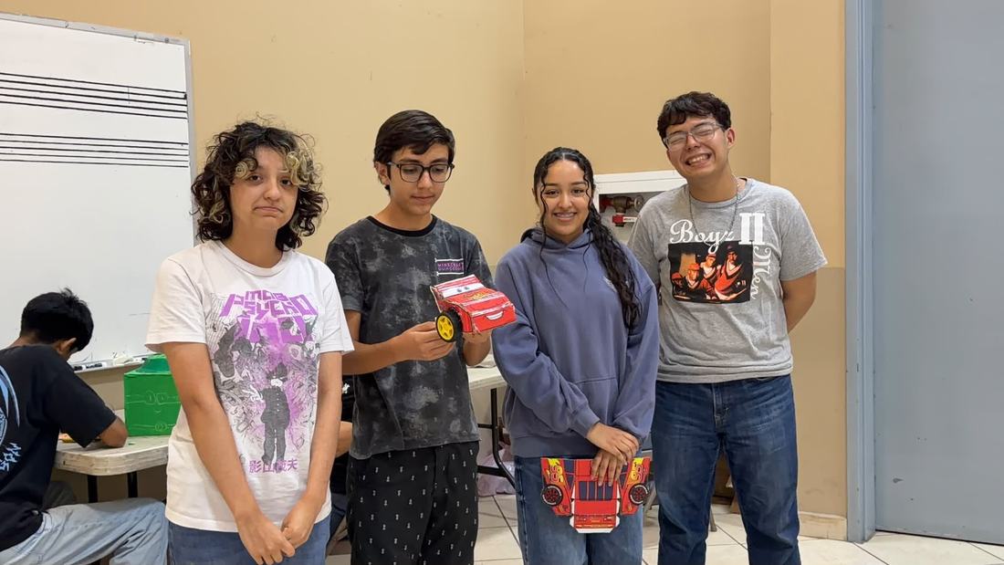 Cuatro alumnos de secundaria muestran los robots que armaron al terminar un taller de robótica de Qubiko