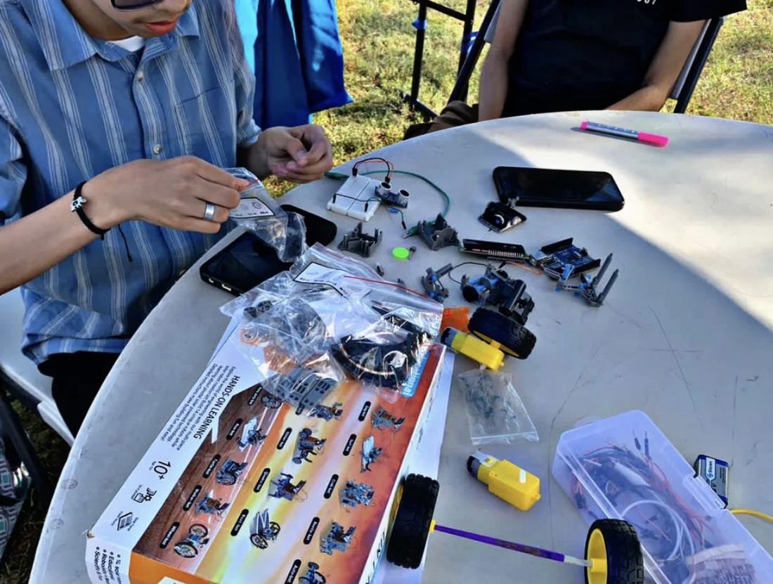 Kit de robótica educativa de Qubiko desplegado sobre la mesa con placas, sensores, motores y ruedas