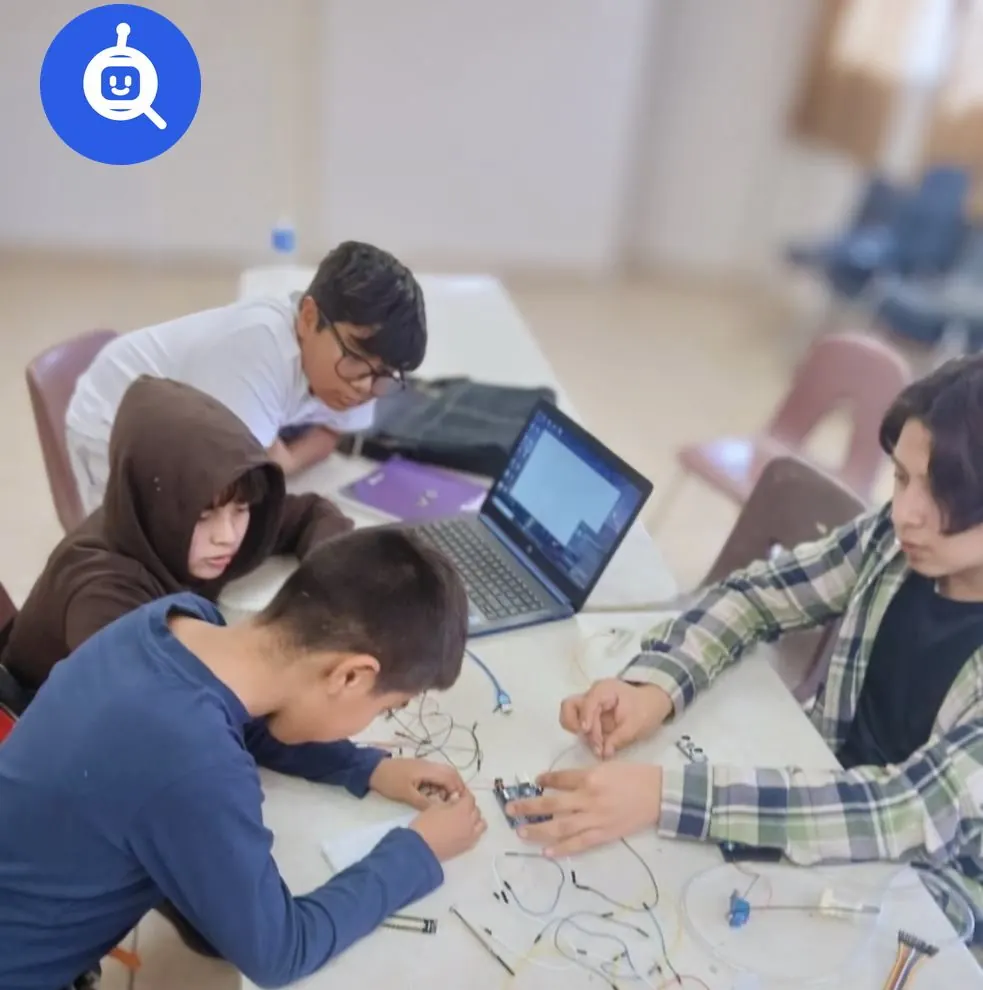 Alumnos trabajando con circuitos y una laptop