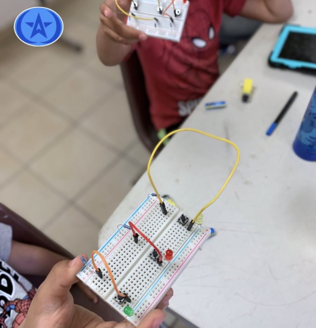 Manos de un alumno sosteniendo una protoboard con un circuito armado en un taller de robótica de Qubiko