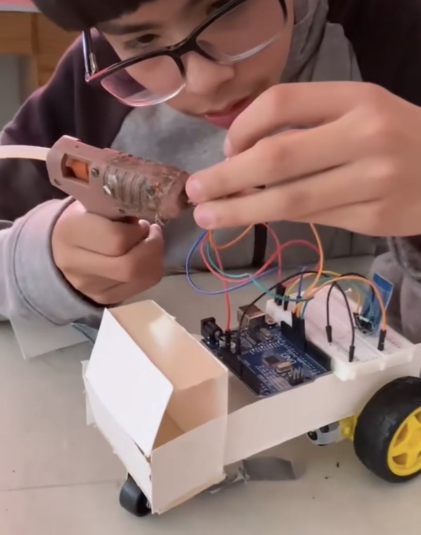Alumno probando el carro robot que armó con Arduino y el kit de robótica de Qubiko